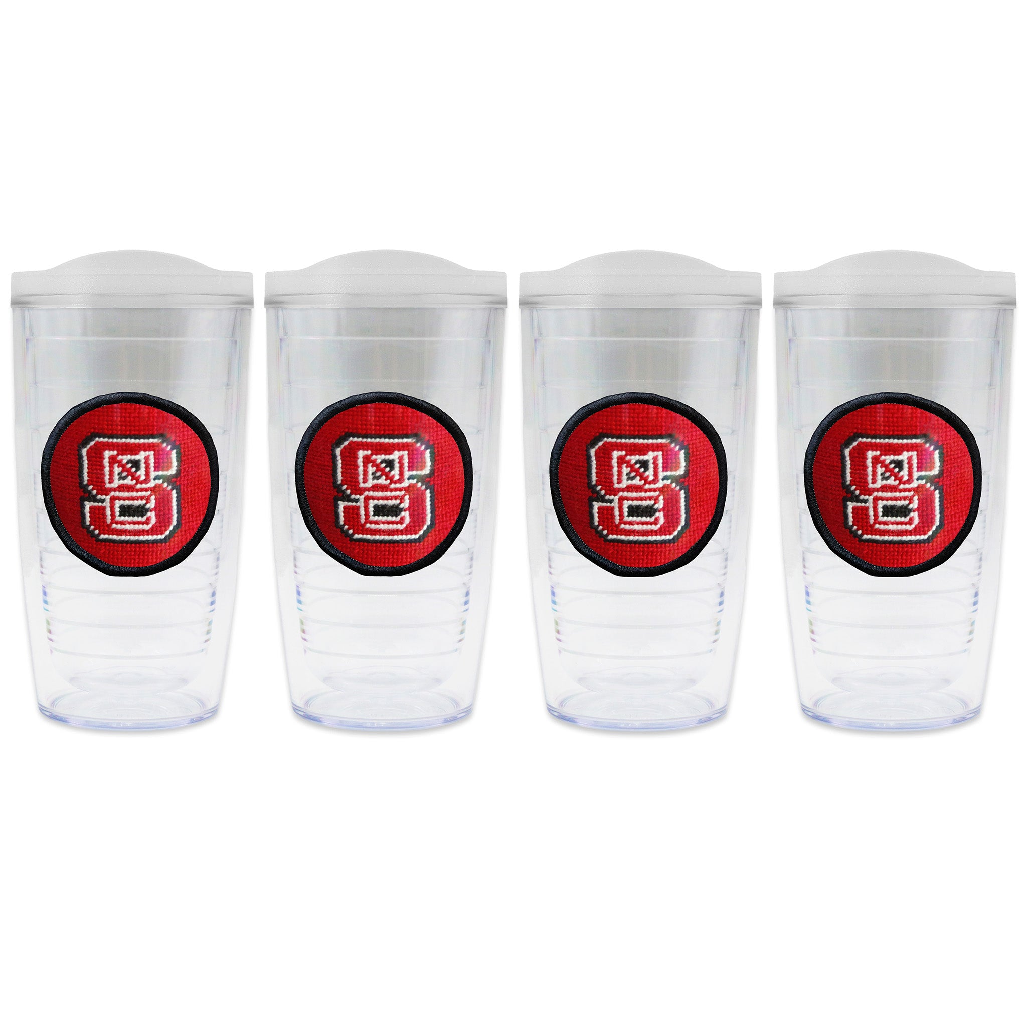 Set of 4 tumblers with lids on each in a line with a needlepoint logo in the center of each tumbler