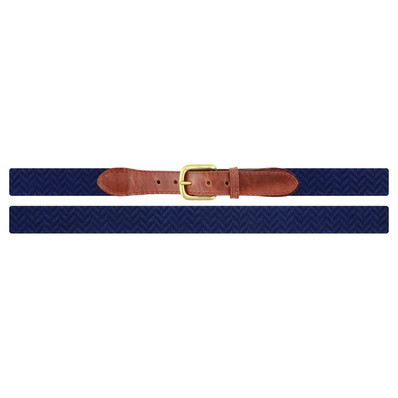 Flat view of Needlepoint Navy Herringbone Belt with brown leather trim and a brass buckle