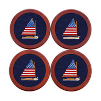 Four coasters with embroidered sailboat design on a blue background