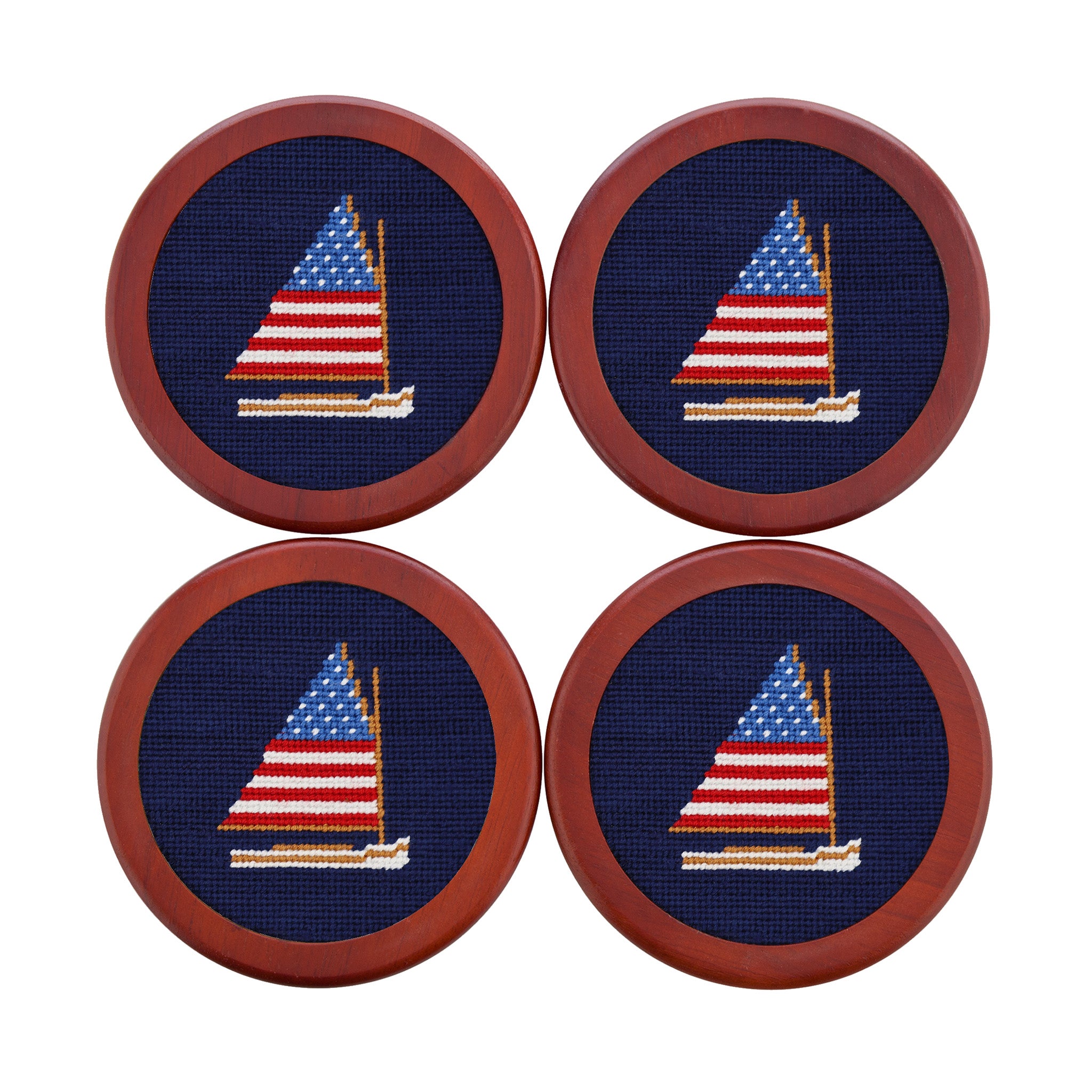 Four coasters with embroidered sailboat design on a blue background