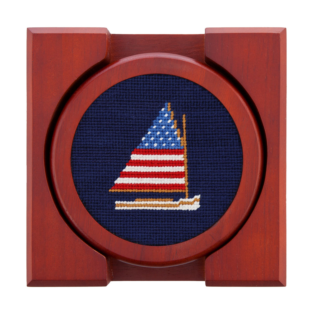 Wooden frame with a cross-stitched sailboat design on a blue background