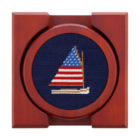 Wooden frame with a cross-stitched sailboat design on a blue background