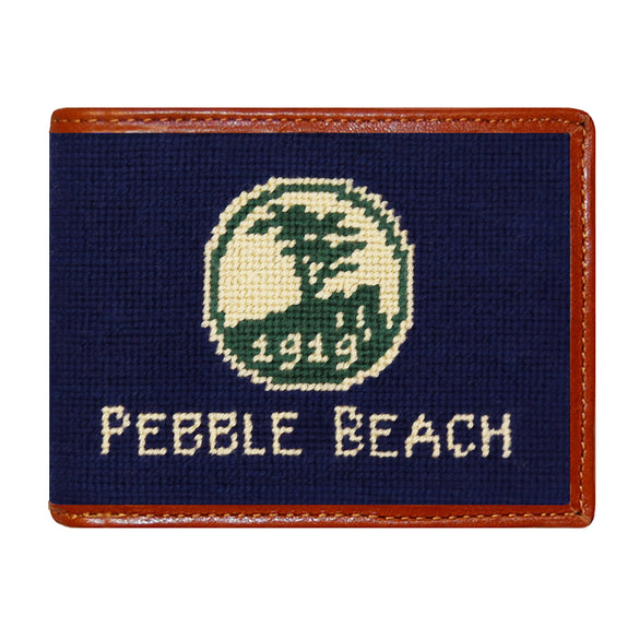 Pebble Beach logo needlepoint bi-fold wallet in dark navy with chestnut leather trim, shown from primary angle.
