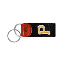 Black needlepoint key fob with the Pittsburgh Pirates “P” logo in gold, brown leather trim, and a metal key ring.