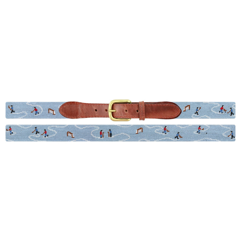Flat view of Needlepoint Pond Hockey Belt with brown leather trim and a brass buckle