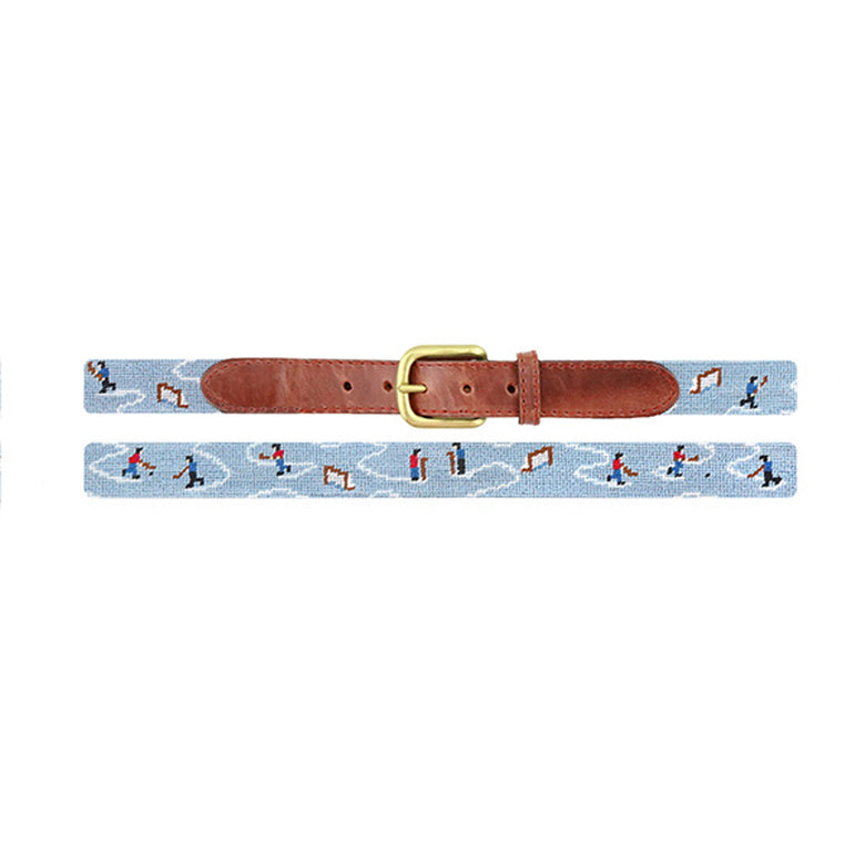 Pond hockey stitched design on a children’s belt with a light blue needlepoint background, brown leather accents, and a brass buckle