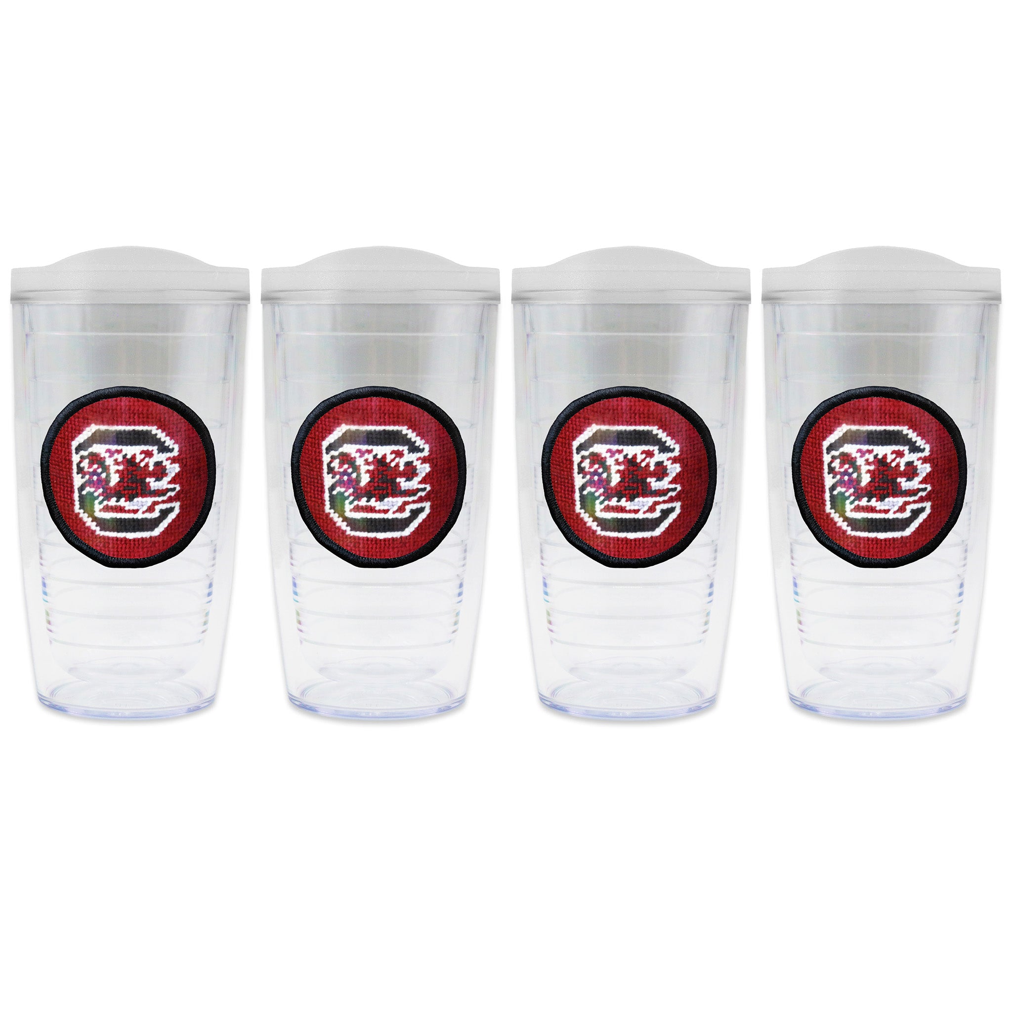 Set of 4 tumblers with lids on each in a line with a needlepoint logo in the center of each tumbler