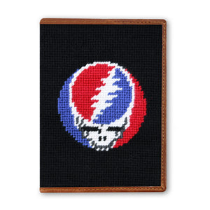 Black needlepoint pouch with a colorful skull design on a white background