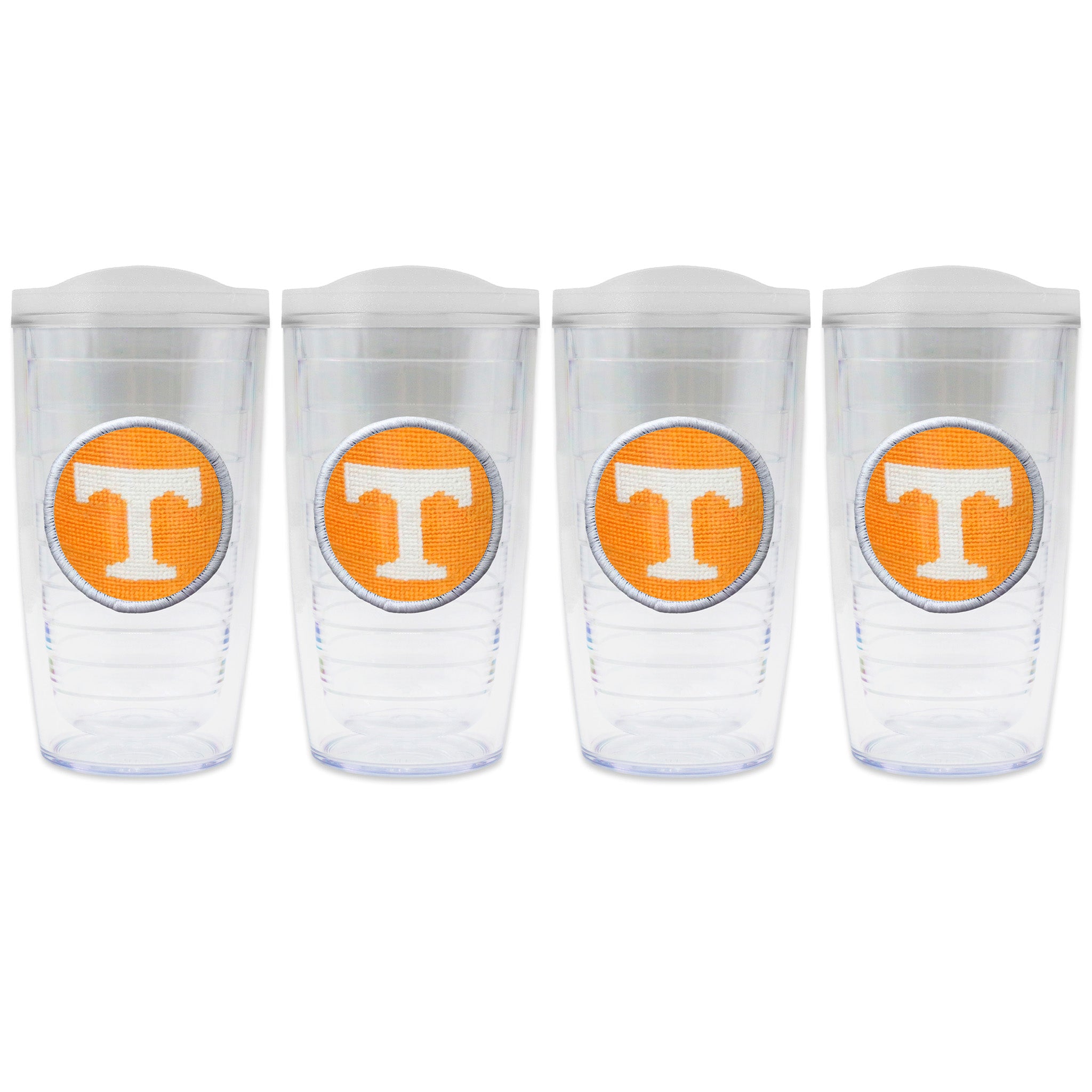Set of 4 tumblers with lids on each in a line with a needlepoint logo in the center of each tumbler