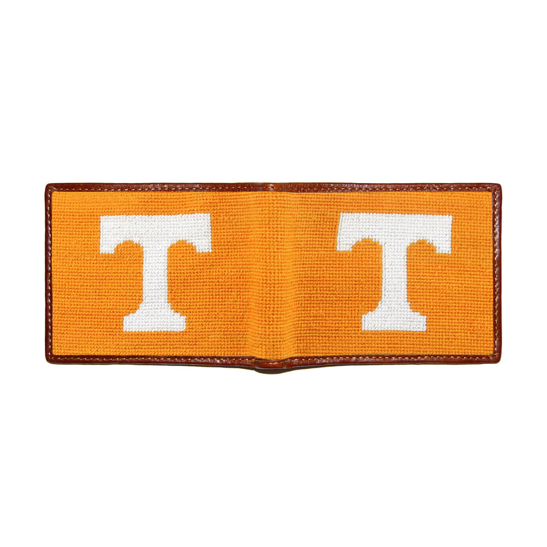 Tennessee burnt orange needlepoint bi-fold wallet open to show both sides of the white “T” logo needlepoint design with brown leather trim.