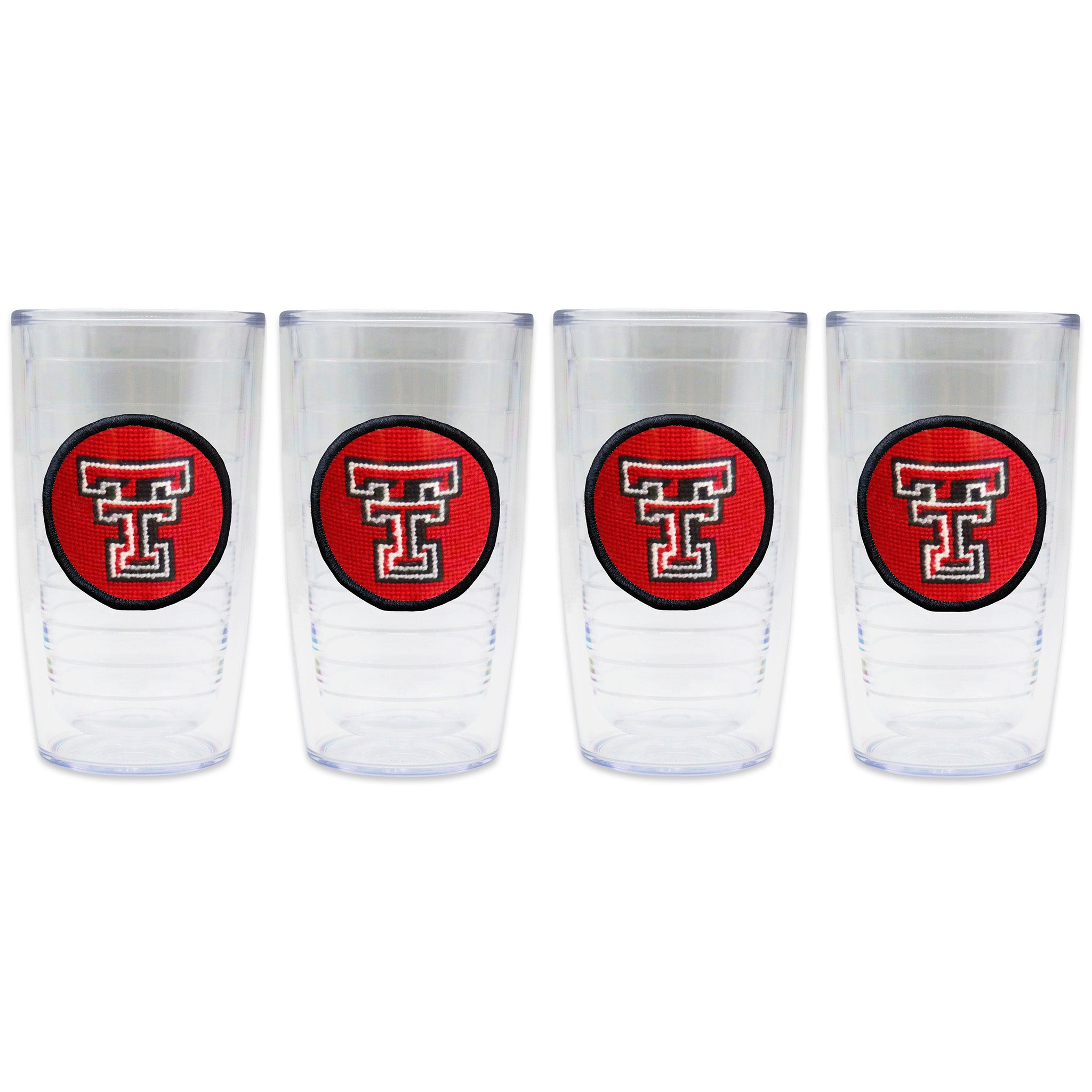 Set of 4 tumblers in a line with a needlepoint logo in the center of each tumbler
