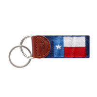 Classic navy needlepoint key fob featuring the Texas state flag, brown leather trim, and a metal key ring.