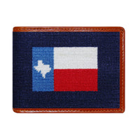Dark navy needlepoint bi-fold wallet with Texas flag design, brown leather trim, shown from primary angle.