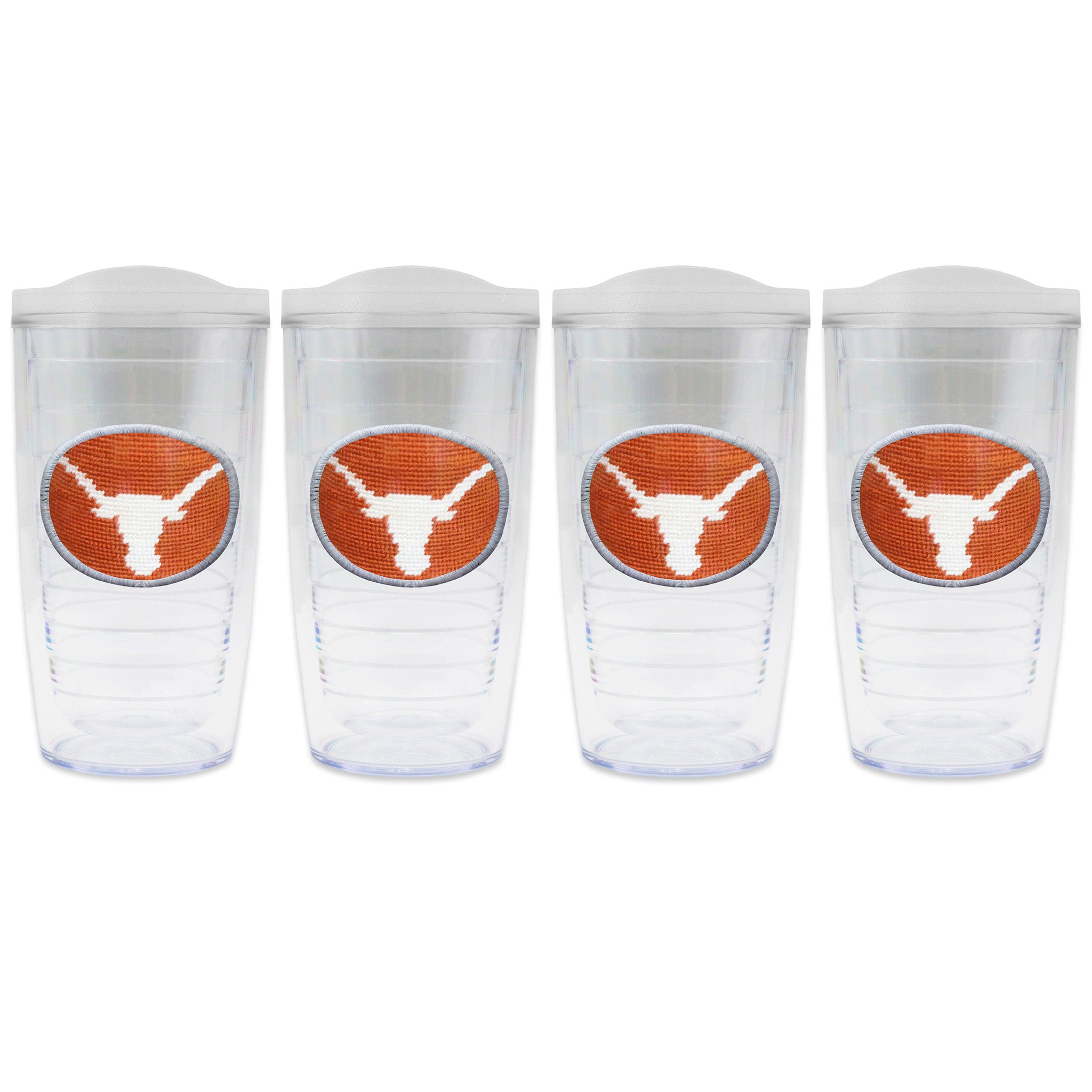 Set of 4 tumblers with lids on each in a line with a needlepoint logo in the center of each tumbler