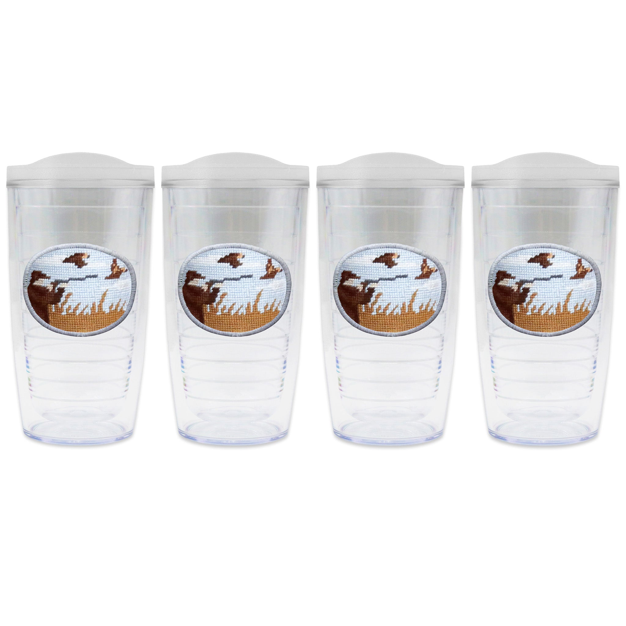 Set of 4 tumblers with lids on each in a line with a needlepoint logo in the center of each tumbler