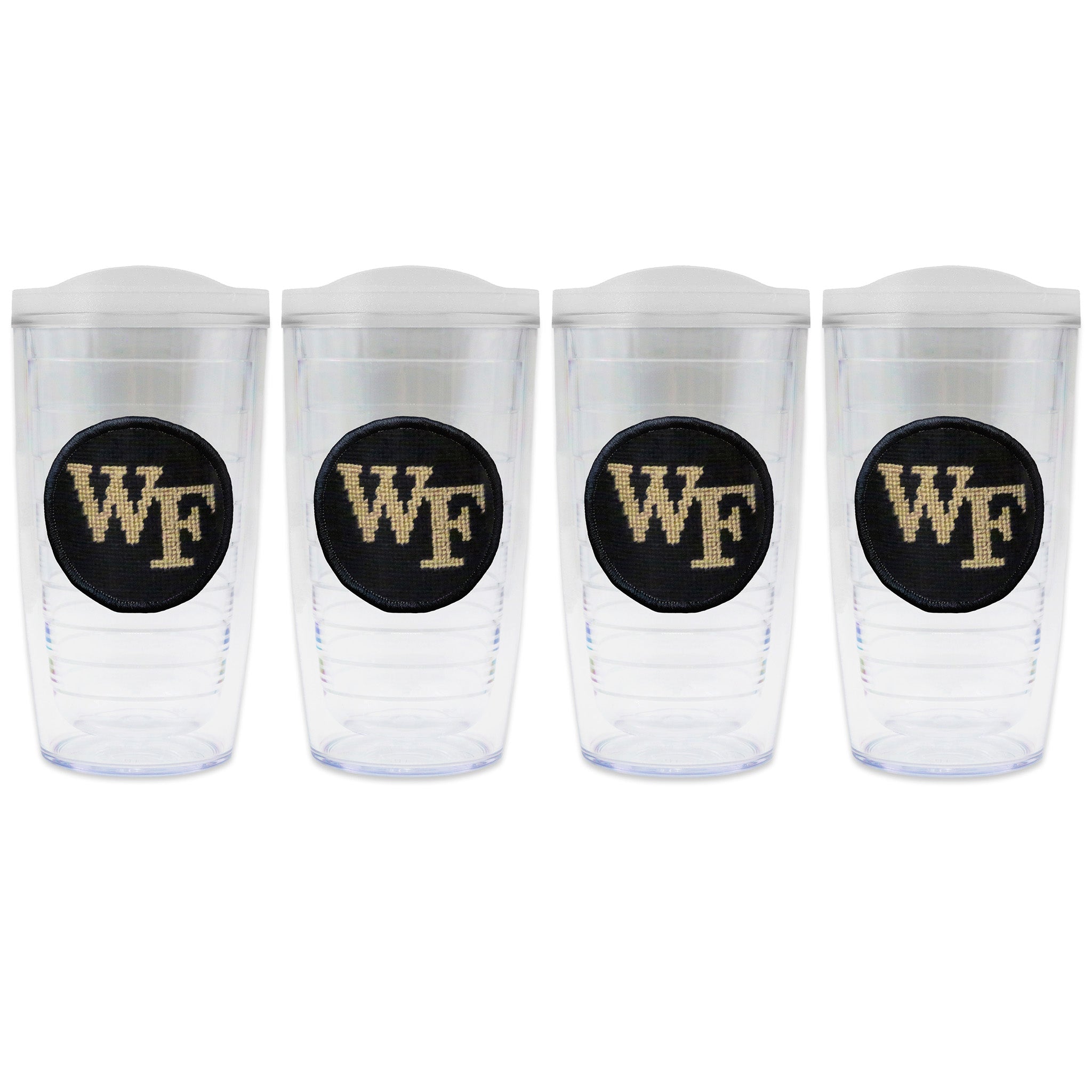 Set of 4 tumblers with lids on each in a line with a needlepoint logo in the center of each tumbler