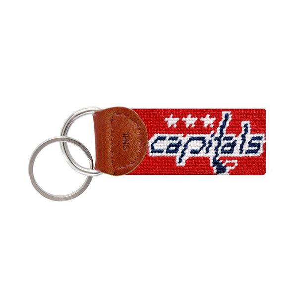 Navy needlepoint key fob featuring the red Washington Capitals logo, brown leather trim, and a metal key ring.