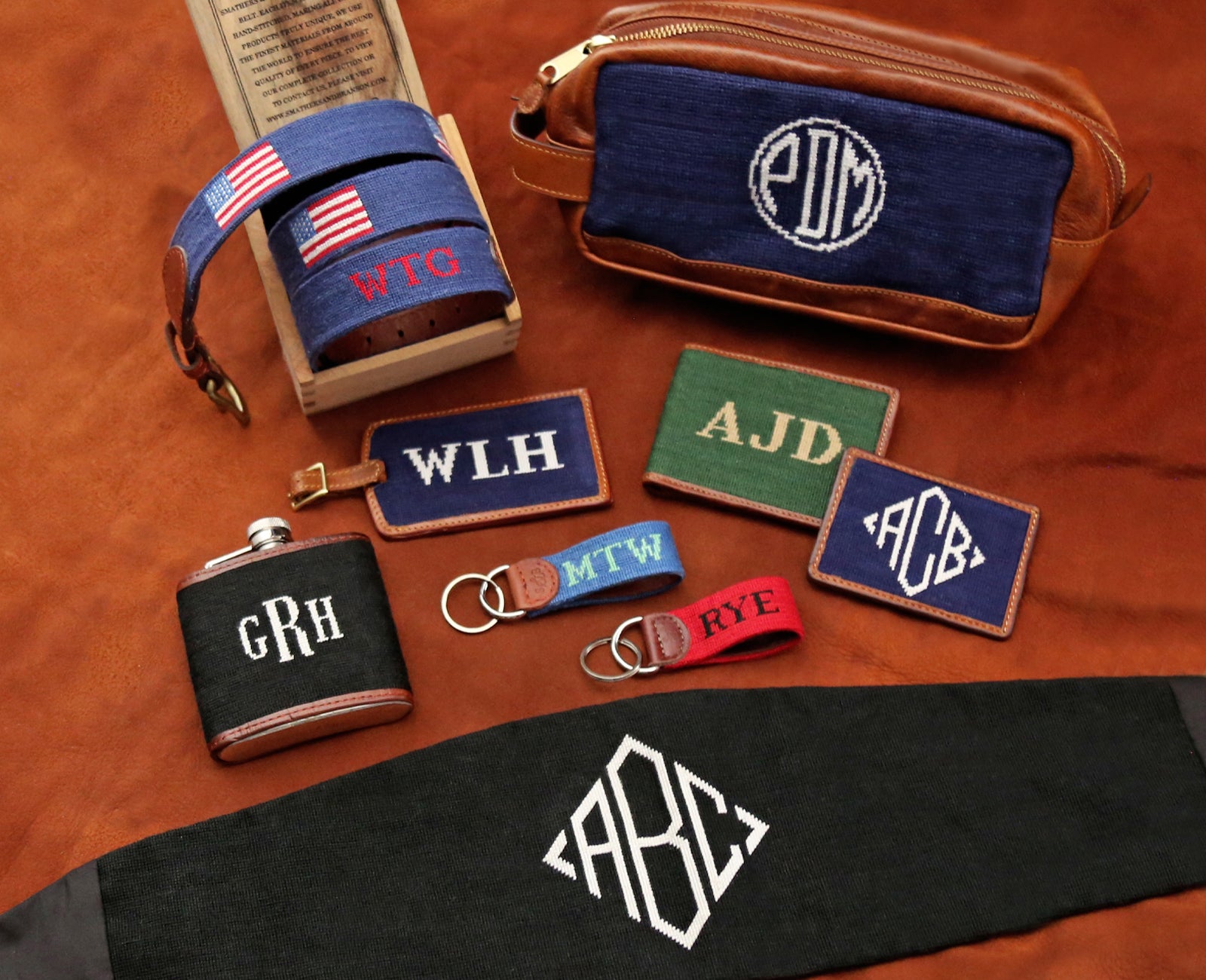 Spread of monogrammed needlepoint belt and accessories laid out.