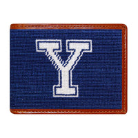 Yale needlepoint bi-fold wallet in navy and white with chestnut leather trim, shown from primary angle.